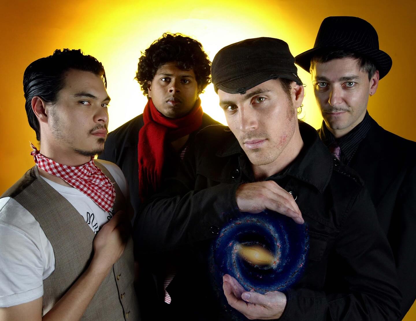 The Tuesday People — early press shot, four members in front of a sunburst, holding a galaxy
